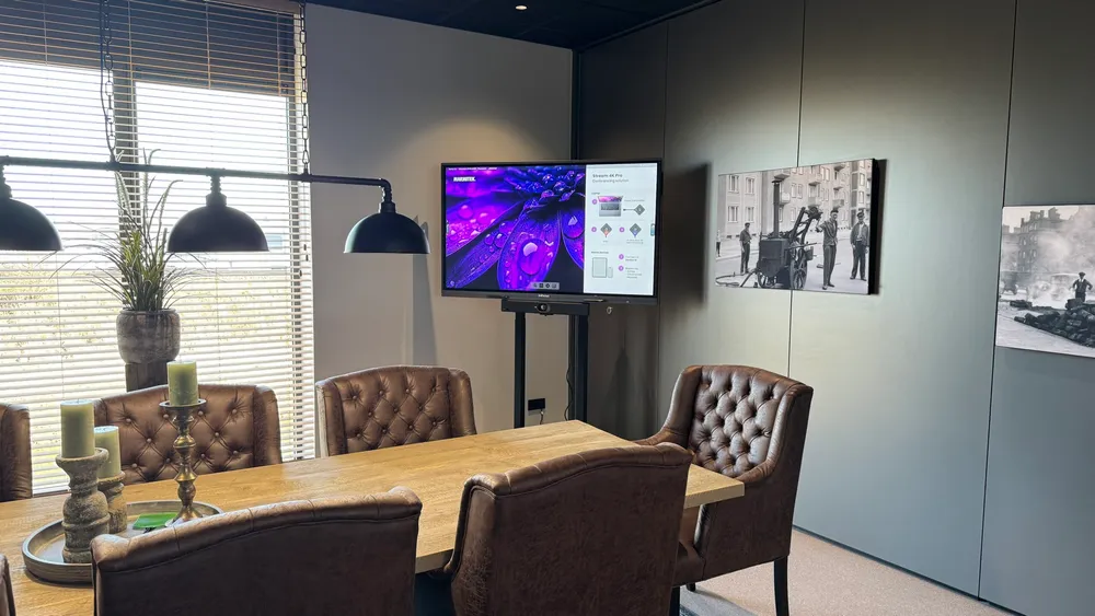 65 inch touchscreen op Neomounts vloerstandaard in vergaderruimte
