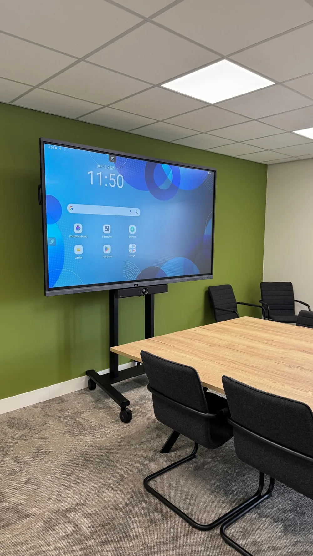 Clevertouch Pro 3 touchscreen met Yealink UVC40 onder het scherm en elektrisch in hoogte verstelbaar Neomounts-statief op wielen.