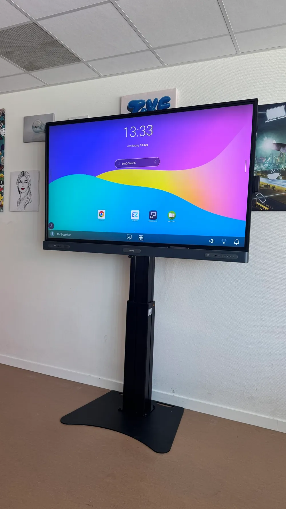 BenQ RP7505-touchscreen met elektrische liftkolom en vlakke vloerplaat, schuin van voren gezien.