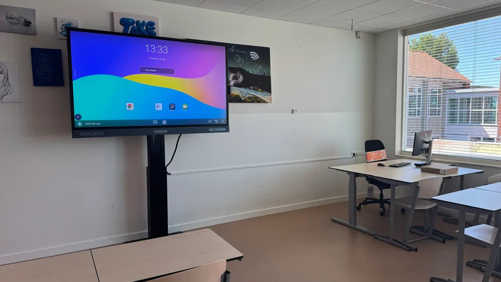 Klaslokaal van Triade in Edam met een BenQ RP7505-digibord op liftkolom naast het docentenbureau.
